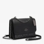 Cartera Coach Klare negra vista tres cuartos con cadena gunmetal