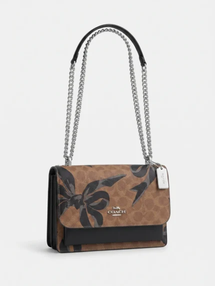Cartera Coach Klare lazos negros vista tres cuartos con cadena plateada