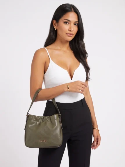 Modelo con cartera Guess verde olivo top blanco