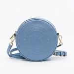 Cartera Michael Kors circular celeste con logo MK grabado