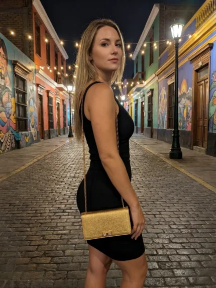 Modelo de noche con clutch Karl Lagerfeld dorada cruzada