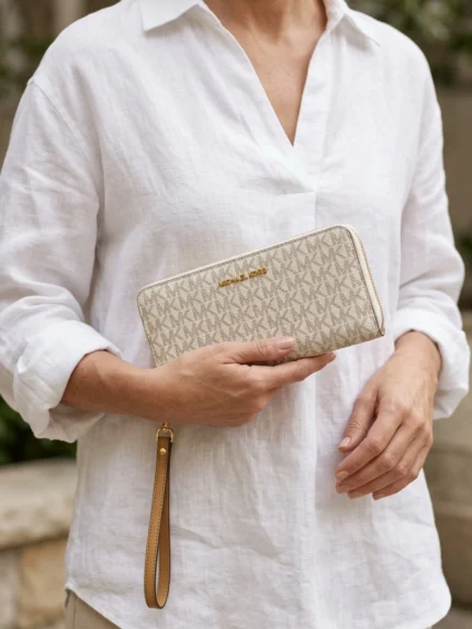 Michael Kors monograma MK beige sobre marfil con cierre y asa camel — en la mano