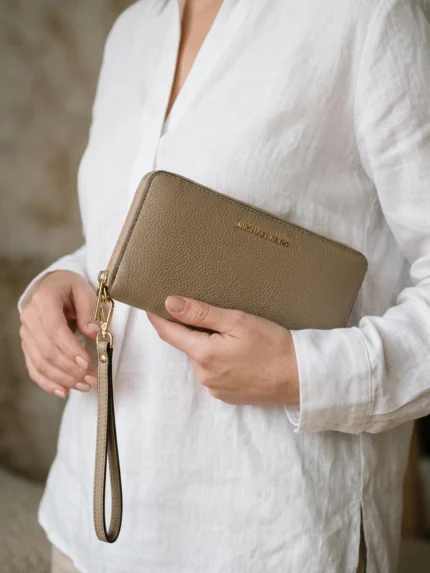 Michael Kors beige topo granulada alargada con cierre y asa — en la mano