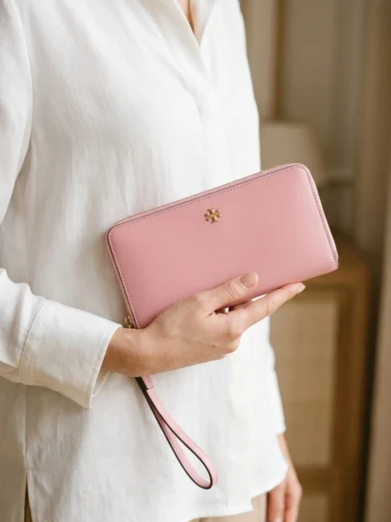 Tory Burch rosa con pequeño logo dorado — en la mano